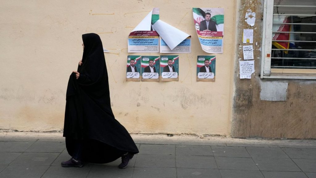 A woman walks past electoral posters of candidates for the March 1, parliamentary election, in downtown Tehran, Iran, Thursday, Feb. 22, 2024.