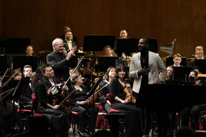 Le directeur musical de l'Orchestre Symphonique National (NSO), Gianandrea Noseda, à gauche, et le compositeur Carlos Simon sourient en acceptant les applaudissements lors d'un concert à La Scala de Milan