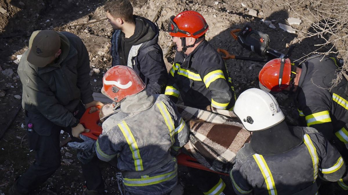 In this photo provided by the Ukrainian Emergency Service, Ukrainian emergency carry an injured person at the site of Russia