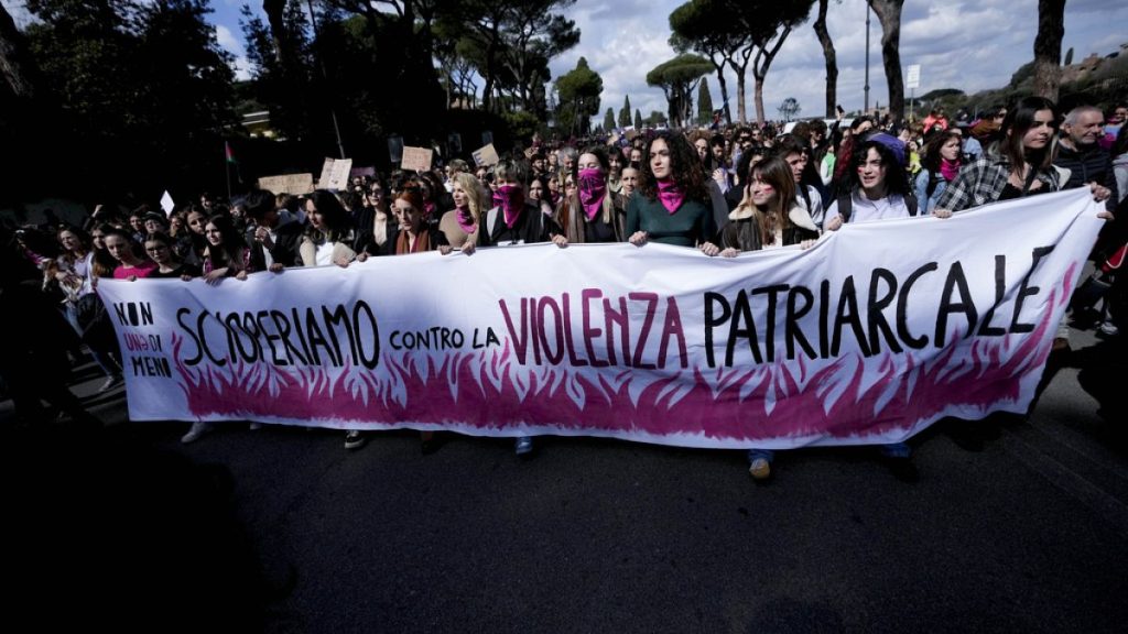 Women hold a banner reading in Italian "We strike against patriarchal violence" during a march to mark International Women