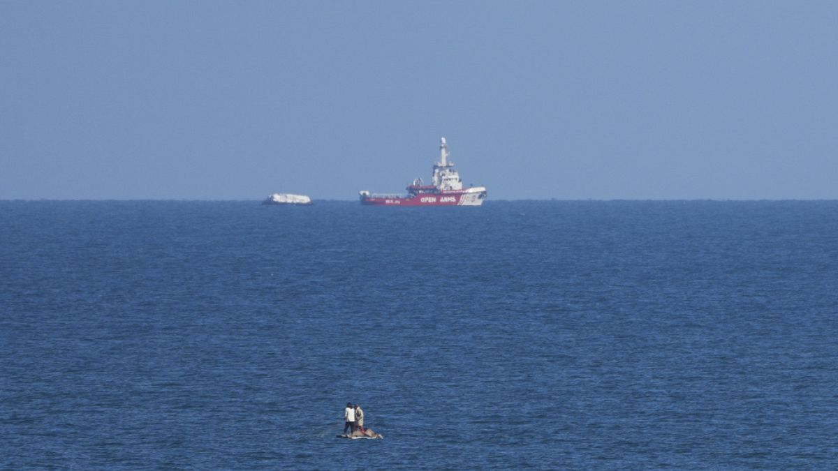 A ship belonging to the Open Arms aid group approaches the shores of Gaza towing a barge with 200 tons of humanitarian aid.