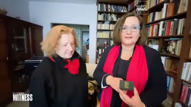 L'éditeur Elżbieta (à gauche) avec l'écrivain Renata (à droite) tenant une boîte contenant leurs alliances