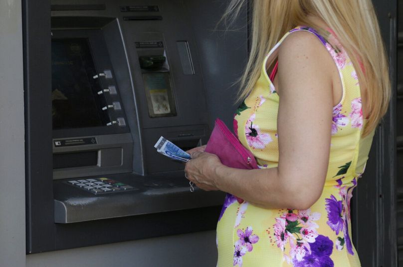 Une femme utilise un distributeur automatique d'une banque à Athènes, juillet 2015.