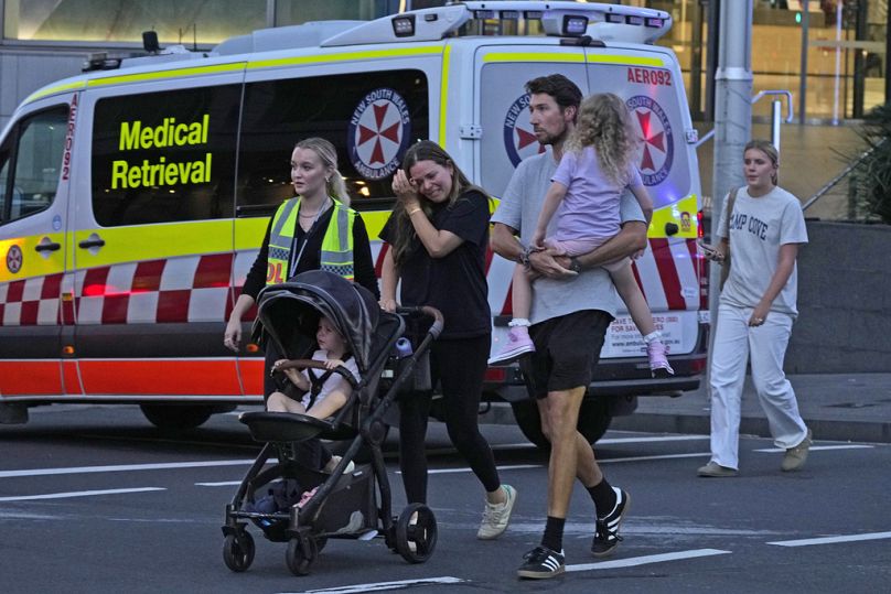Des gens sont emmenés hors du centre commercial Westfield où plusieurs personnes ont été poignardées à Sydney, le samedi 13 avril 2024.