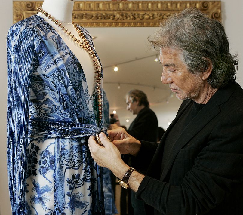 Roberto Cavalli ajustant une de ses robes sur un mannequin en 2005.