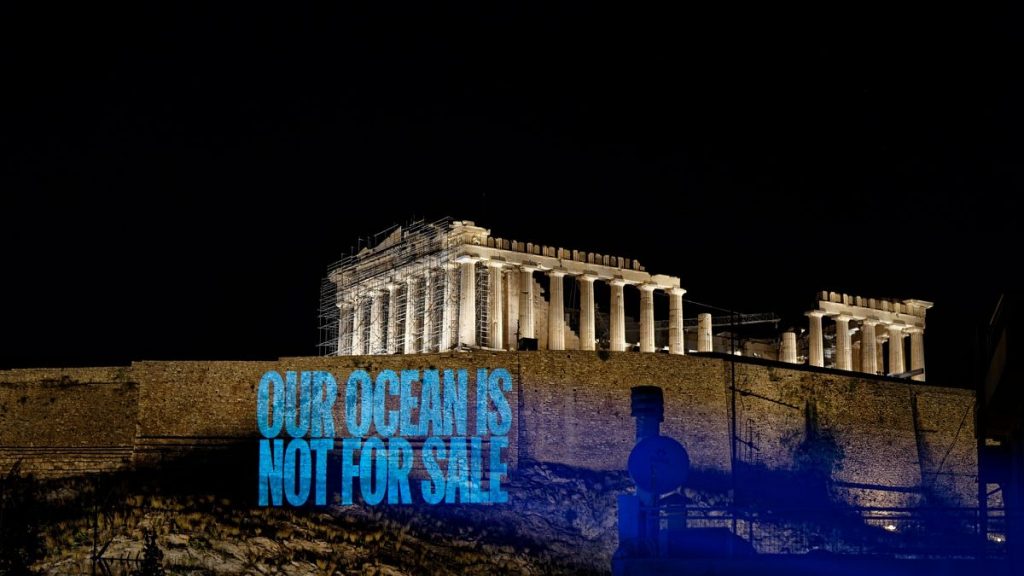 Greenpeace Greece activists project a message reading:
