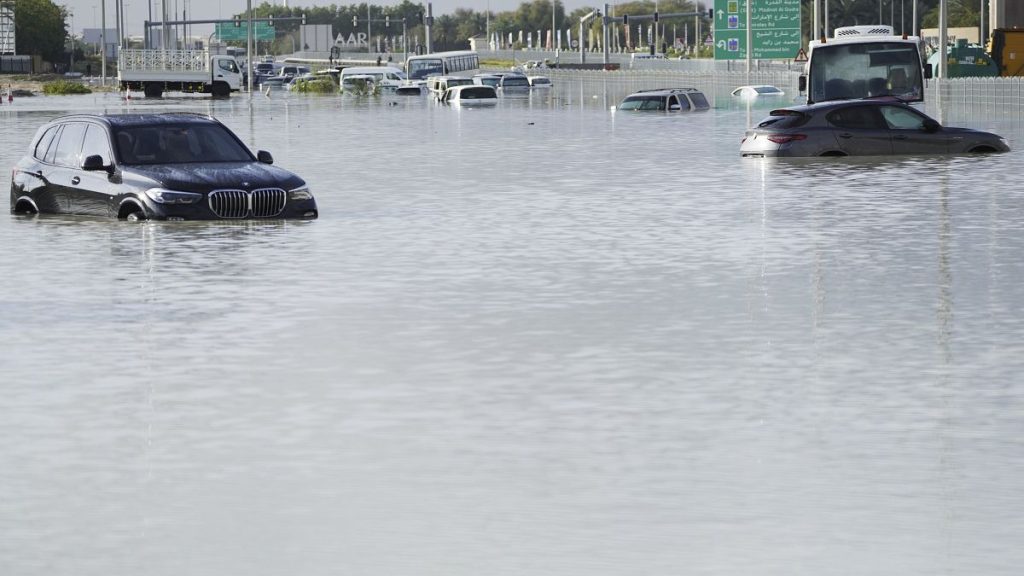 Vehicles sit abandoned in floodwater covering a major road in Dubai, United Arab Emirates