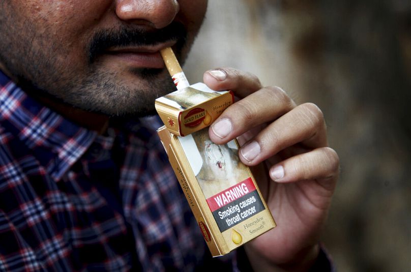 Un homme prend une cigarette dans un paquet à New Delhi, novembre 2016