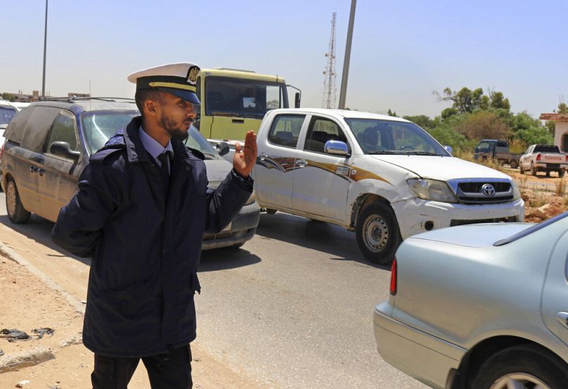 un policier fait passer des véhicules à un point de contrôle aux heures de pointe à Benghazi, mai 2019
