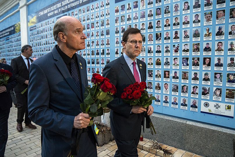 Des membres du Congrès américain déposent des fleurs sur un mur commémoratif pour les soldats ukrainiens tués pendant la guerre à la cathédrale Saint-Michel de Kiev