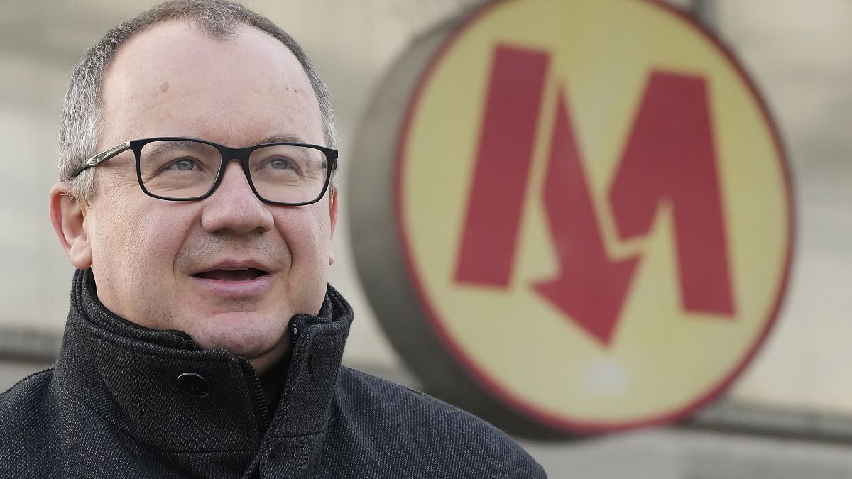 Human rights lawyer Adam Bodnar hands out flyers to morning commuters as he runs in his first election, for a seat in the Senate with the opposition Civic Coalition.