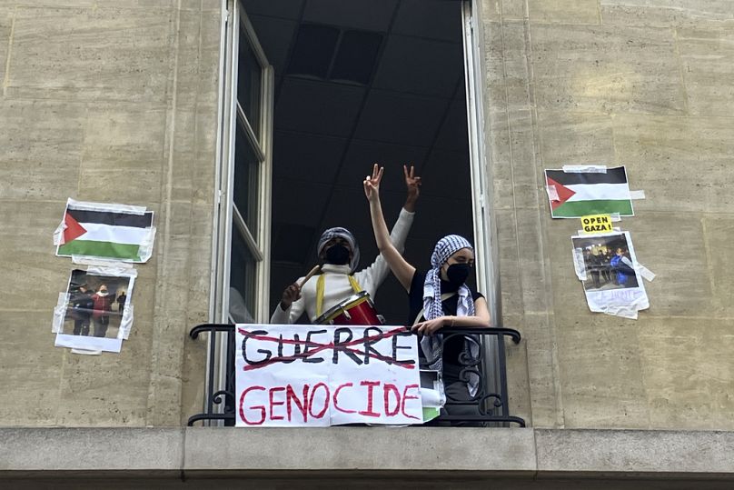 Les étudiants bloquant l'université de Sciences-Po arborent le panneau V vendredi 26 avril 2024 à Paris.