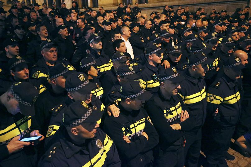 Des policiers bloquent les manifestants alors qu'ils se rassemblent devant le bâtiment du Parlement à Tbilissi, le 16 avril 2024.