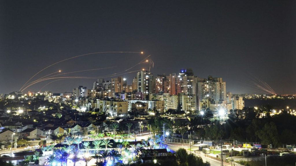 A man walks past a mural depicting the U.S. president Joe Biden as a superhero defending Israel on a street in Tel Aviv, Israel, Sunday, April 14, 2024.