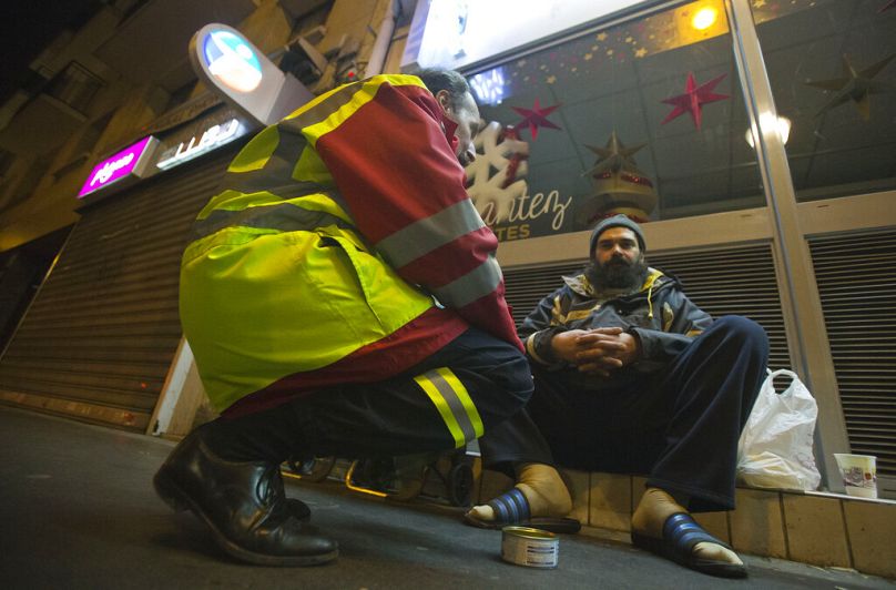 Un bénévole de l'Ordre de Malte Bertand de Villermont auprès d'un sans-abri à Boulogne-Billancourt, près de Paris, décembre 2014