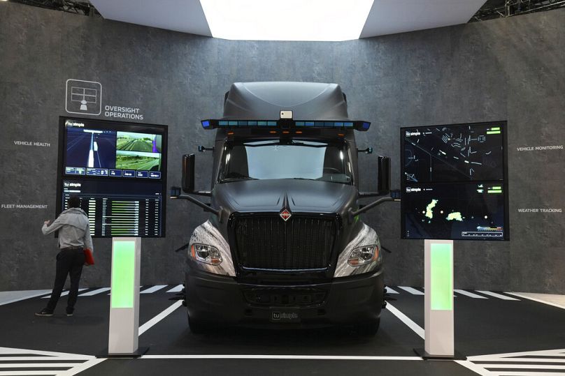 Une personne examine la technologie de conduite autonome sur un camion exposé lors du salon technologique CES à Las Vegas, janvier 2022.