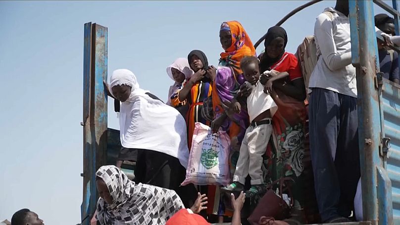 Des réfugiés débarquent d'un camion transportant de nouveaux arrivants vers un centre de transit dans l'État du Haut-Nil, au Soudan du Sud.