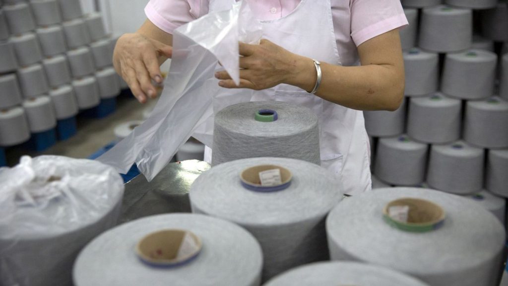 A worker packages spools of cotton yarn at a textile manufacturing plant, as seen during a government organized trip for foreign journalists, in Aksu in China
