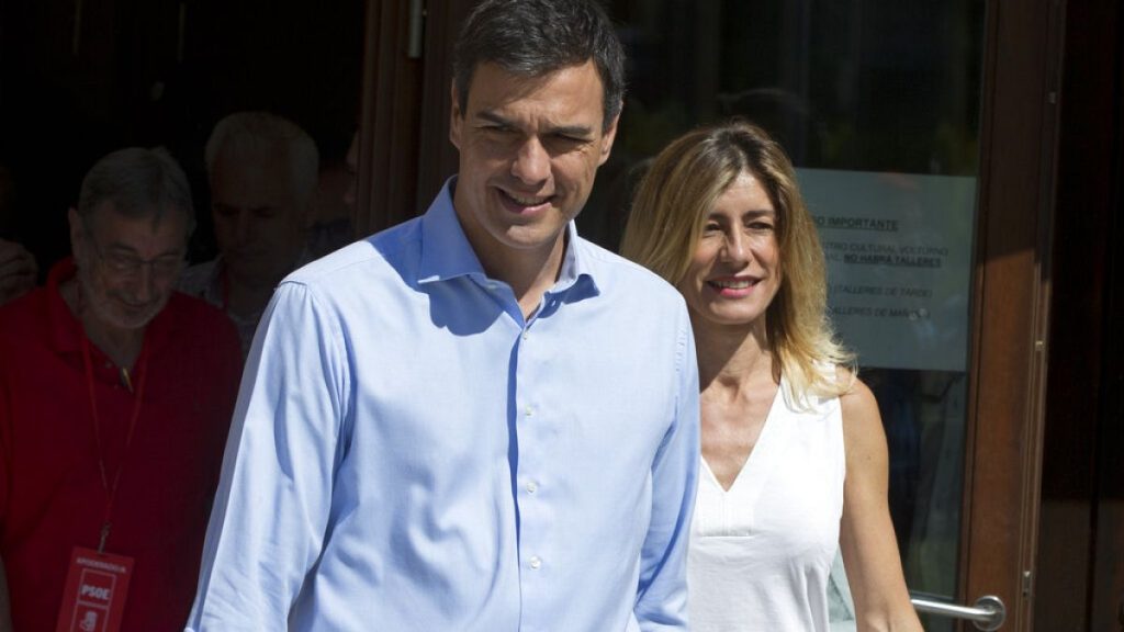 A journalist gives Spanish socialist leader Pedro Sanchez and his wife Begona Gomez leave a polling station during the national elections in Madrid, Spain, Sunday, June. 25