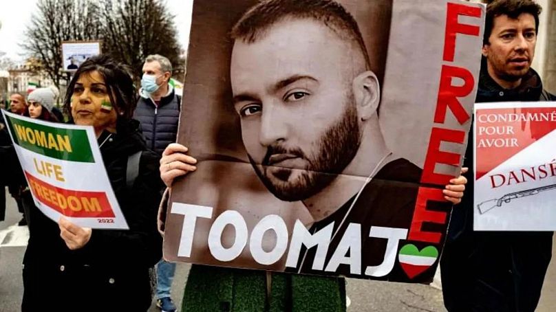 Une femme tient une affiche du rappeur Toomaj Salehi, arrêté pour son soutien aux manifestations de Mahsa Amini