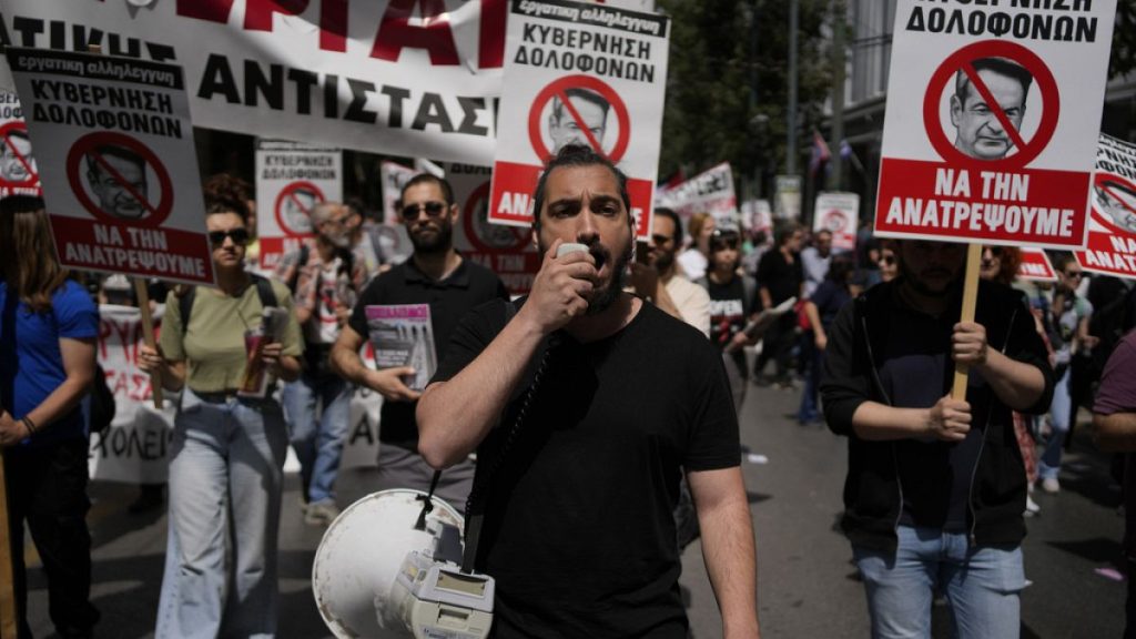 Protesters hold banners during a rally in Athens, Greece, Wednesday, April 17, 2024.