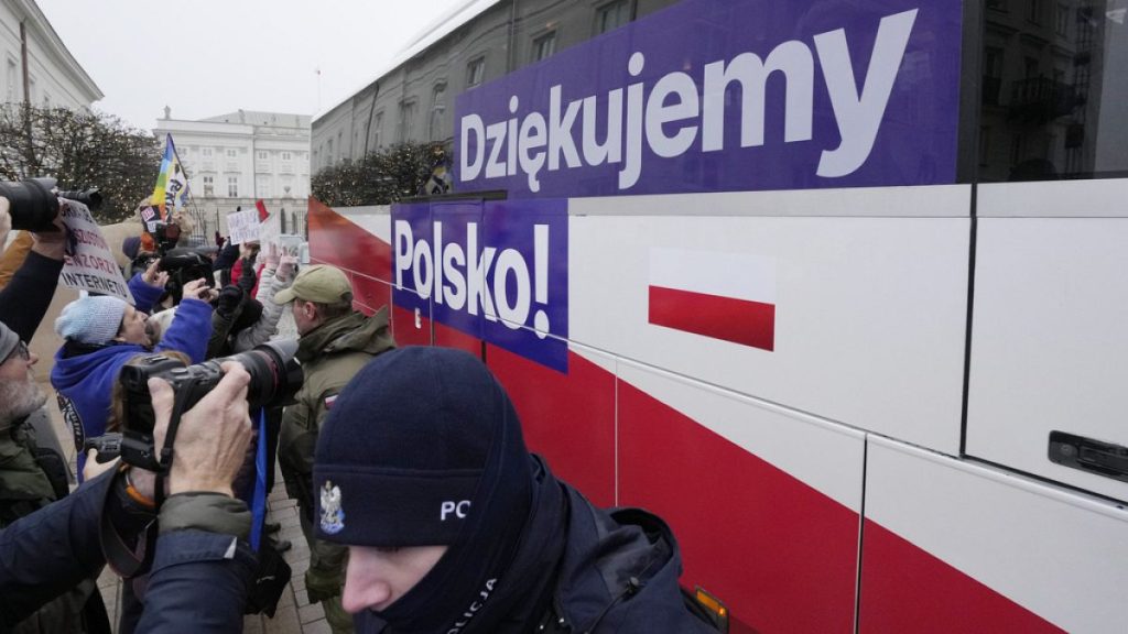 People cheer as a bus carrying Polish Prime Minister Donald Tusk and his ministers leave heading to the presidential palace in Warsaw, Poland (AP Photo/Czarek Sokolowski)