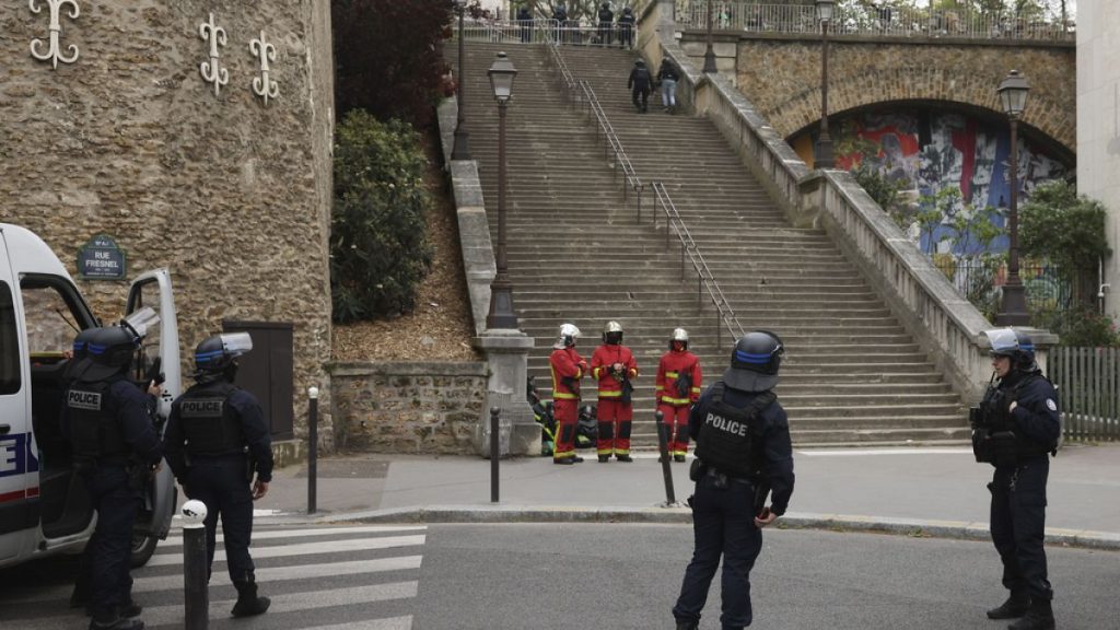 Police officers and rescue worker wait for instructions bar the the Iranian consulate, Friday, April 19, 2024 a in Paris