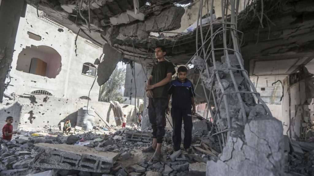Palestinians stand in the ruins of the Chahine family home, after an overnight Israeli strike in Rafah, southern Gaza Strip, Friday, May 3, 2024.