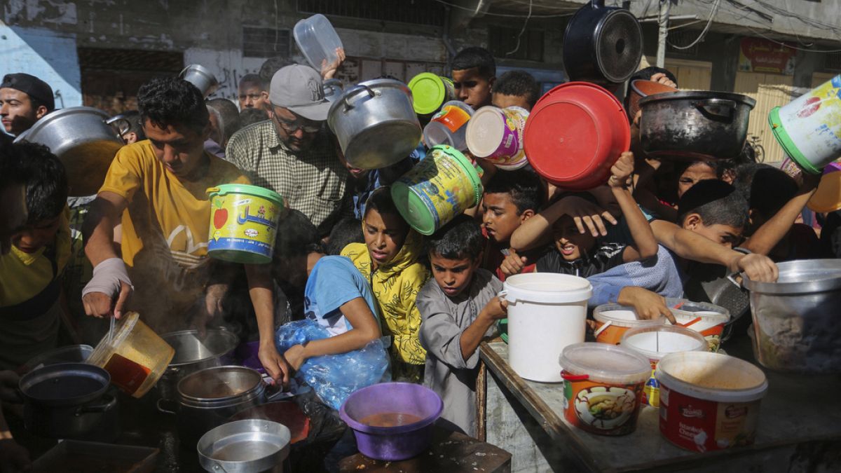 FILE - Palestinians crowd together as they wait for food distribution in Rafah, southern Gaza Strip, Nov. 8, 2023.