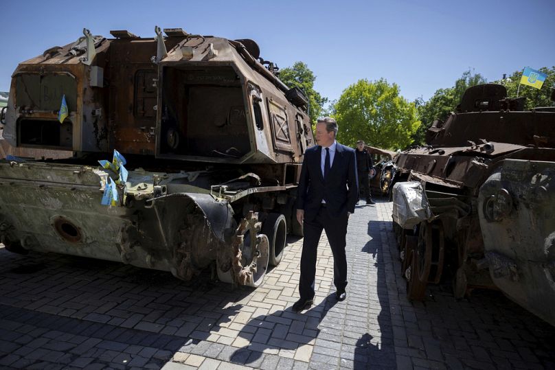 Le ministre britannique des Affaires étrangères David Cameron passe devant une exposition de véhicules militaires russes détruits sur la place Saint-Michel, à Kiev, en Ukraine, le jeudi 2 mai 2024.
