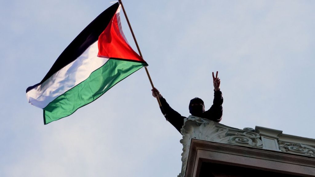 A student protester waves a Palestinian flag above Hamilton Hall on the campus of Columbia University, Tuesday, April 30, 2024, in New York.