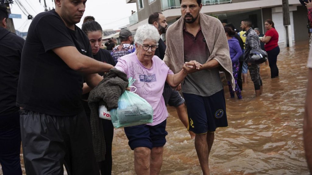 Residents evacuate from a neighborhood flooded by heavy rains, in Canoas, Rio Grande do Sul state, Brazil on Saturday