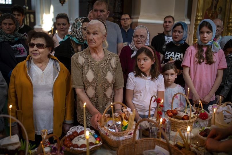 Les croyants attendent qu'un prêtre orthodoxe lituanien bénisse les gâteaux traditionnels et les œufs peints collectés pour leur célébration de Pâques le 5 mai.