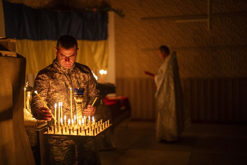 Un militaire ukrainien de la 72e Brigade mécanisée séparée allume des bougies lors d'un service religieux chrétien orthodoxe de Pâques, dans la région de Donetsk, en Ukraine.