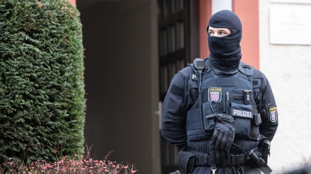 FILE - Police officers stand by a searched property in Frankfurt during a raid against so-called