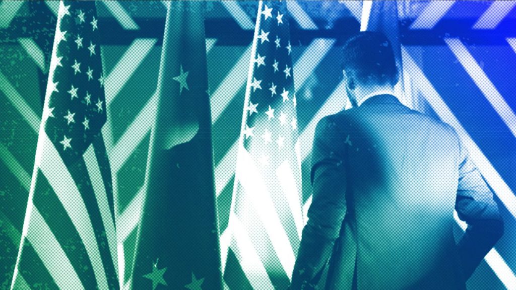 A staffer adjusts the US and EU flags at the European Council building in Brussels, April 2023