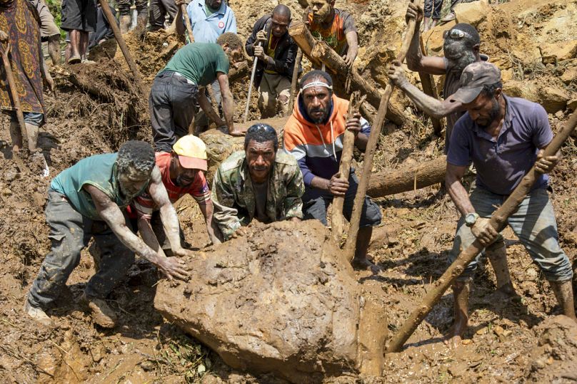 Sur cette photo publiée par le PNUD Papouasie-Nouvelle-Guinée, des villageois fouillent un glissement de terrain dans le village de Yambali, dans les hautes terres de Papouasie-Nouvelle-Guinée.
