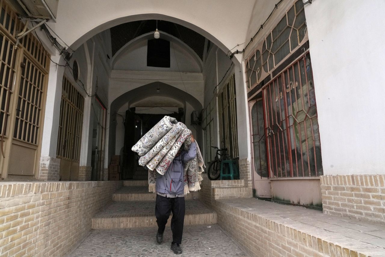Un ouvrier transporte des tapis au bazar traditionnel de la ville de Kashan, à environ 245 km au sud de la capitale Téhéran, en Iran, le mardi 30 avril 2024.