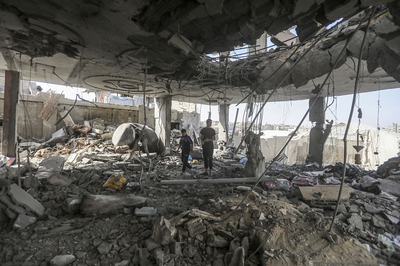Des Palestiniens se tiennent dans les ruines d'une maison après une frappe israélienne nocturne qui a tué au moins deux adultes et cinq enfants à Rafah, le 3 mai 2024.