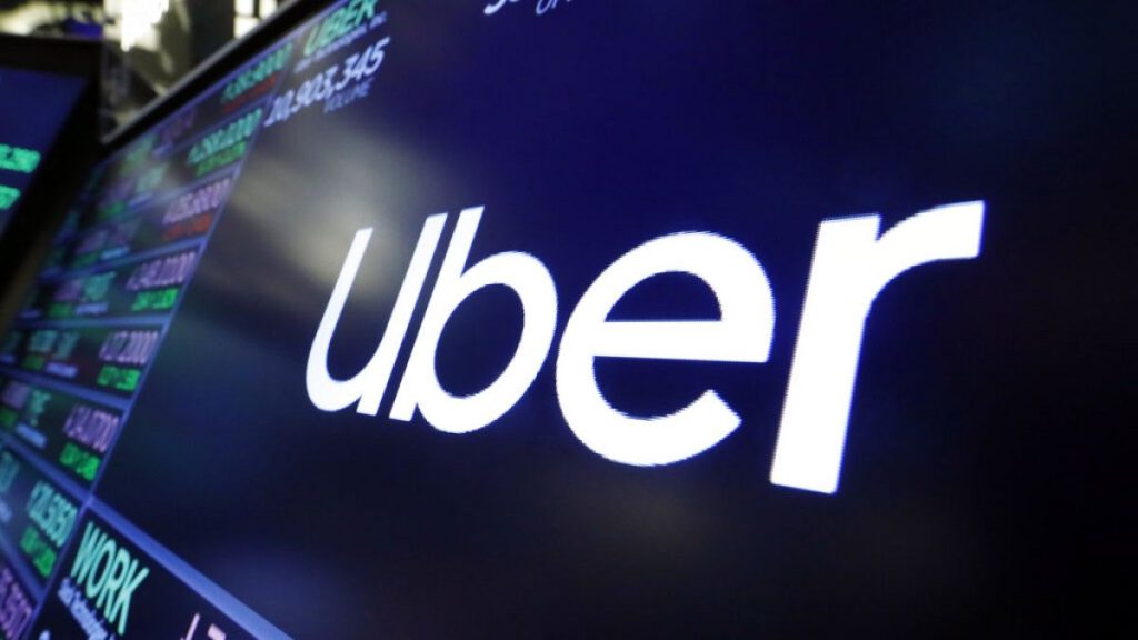 In this Aug. 16, 2019 file photo, the logo for Uber appears above a trading post on the floor of the New York Stock Exchange.