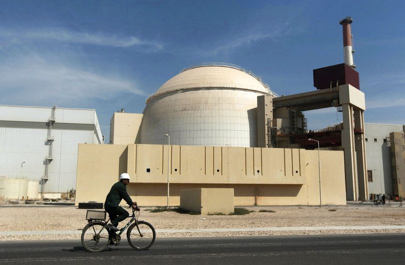 Un ouvrier roule à vélo devant le bâtiment du réacteur de la centrale nucléaire de Bouchehr, juste à l'extérieur de la ville méridionale de Bouchehr, en Iran, le 26 octobre 2010.