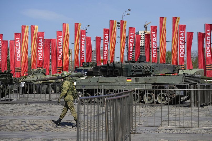 Un soldat russe passe devant un char Leopard 2A6 ayant appartenu à l’armée ukrainienne, exposé à Moscou. Mardi 30 avril 2024.