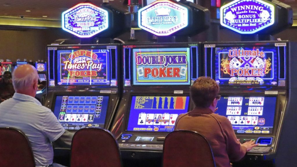 Gamblers play slot machines at Harrah