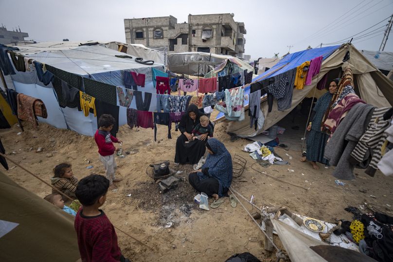 Des Palestiniens déplacés par les bombardements israéliens sur la bande de Gaza prennent le thé dans le camp de tentes de fortune de la région de Muwasi, le jeudi 28 décembre 2023.