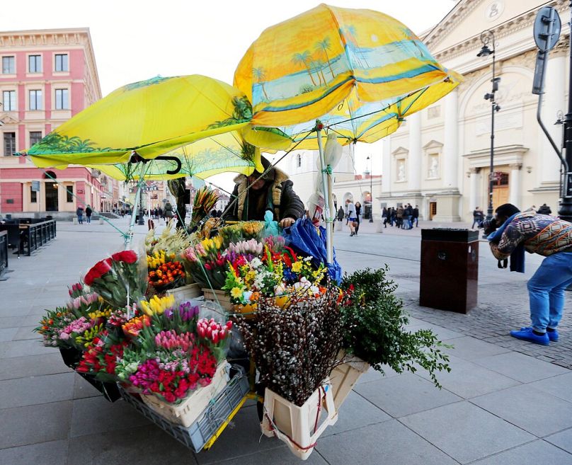 DOSSIER – Un vendeur ambulant tire un vélo vendant des fleurs dans la vieille ville le jour de Pâques à Varsovie, en Pologne, le dimanche 27 mars 2016.