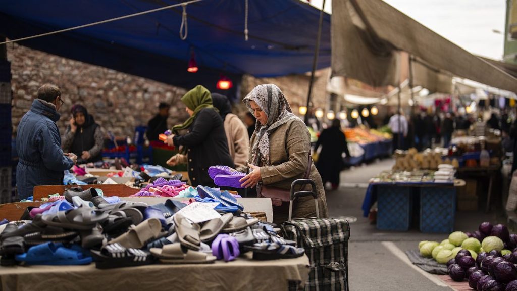 People buy goods and food at a street market in Istanbul (file photo)