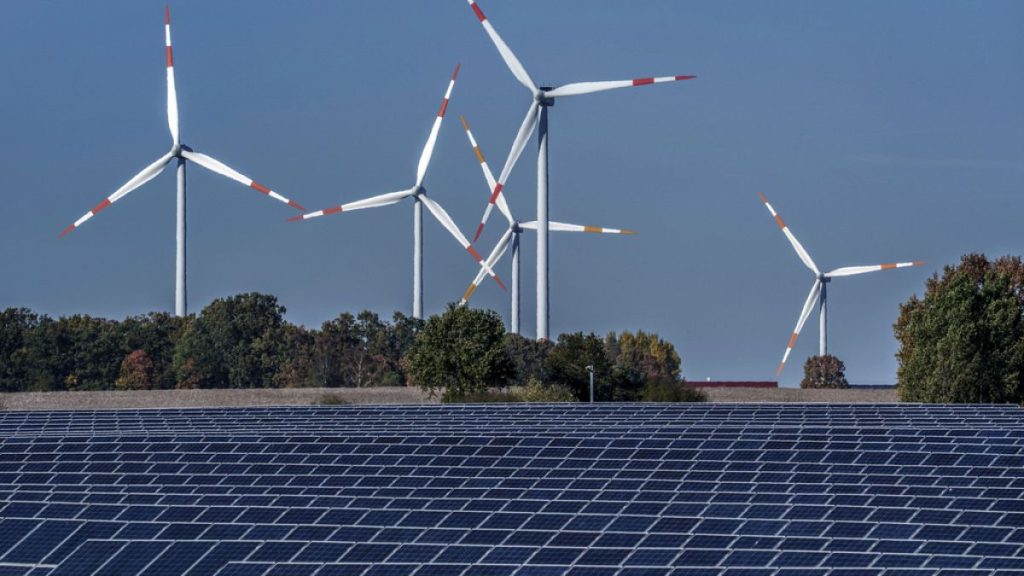 Wind turbines turn behind a solar farm in Rapshagen, Germany.