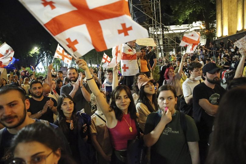 Des manifestants brandissent le drapeau national géorgien lors d'une manifestation de l'opposition contre 