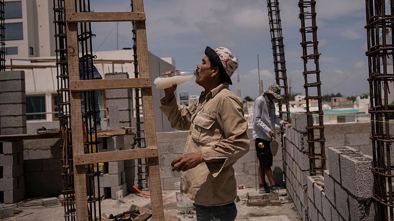 Jorge Moreno, un ouvrier, boit de l'eau aromatisée pour faire face à la canicule pendant sa journée de travail sur un chantier de construction à Veracruz, au Mexique, le 17 juin 2024.