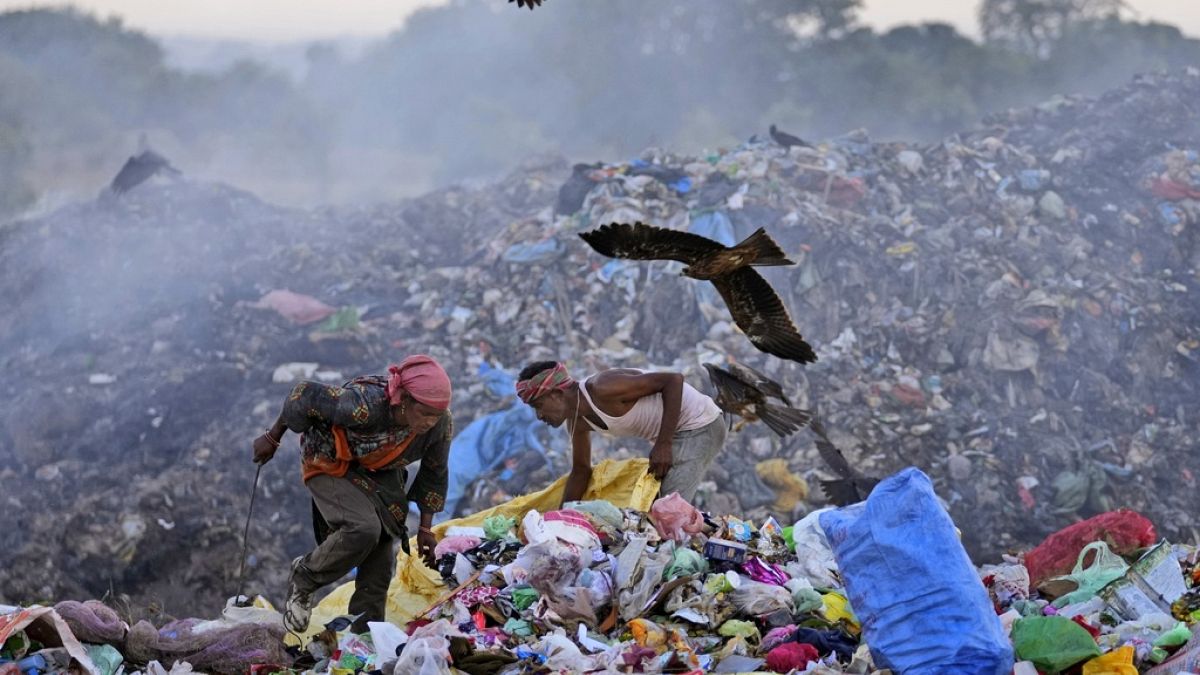 Waste pickers Salmaa and Usmaan Shekh, right, search for recyclable materials during a heat wave at a garbage dump on the outskirts of Jammu, India